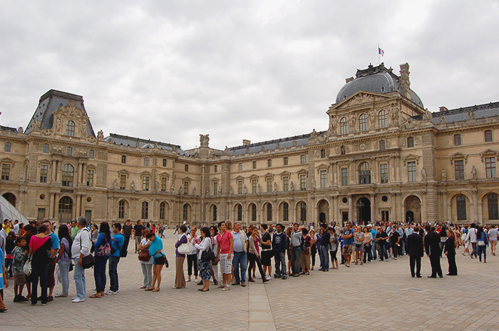 Massen von Touristen stehen vor dem Louvre Schlange