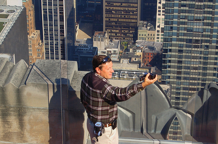 A tourist taking a selfie on top of a skyscraper in New York