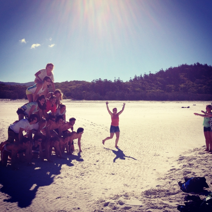 Reasons to visit Australia: A bunch on young people making jokes at a beach in Australia