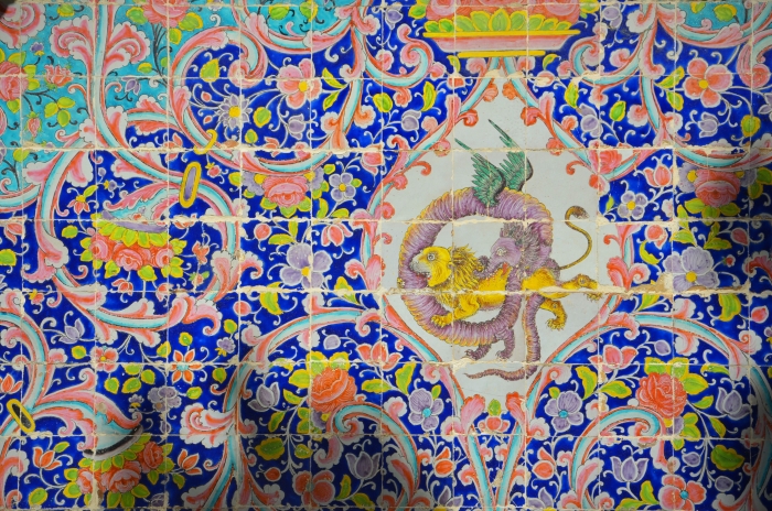 A close shot of tiles showing a dragon and a lion fighting in the Golestan Palace in Tehran